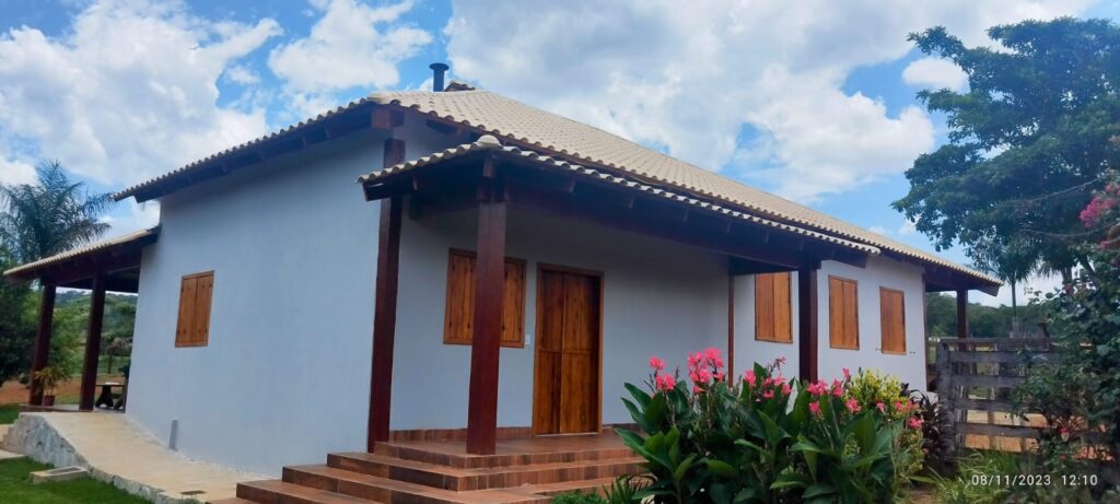 Casa residencial concluída pela STYL Construtora, com fachada clara, varanda e paisagismo